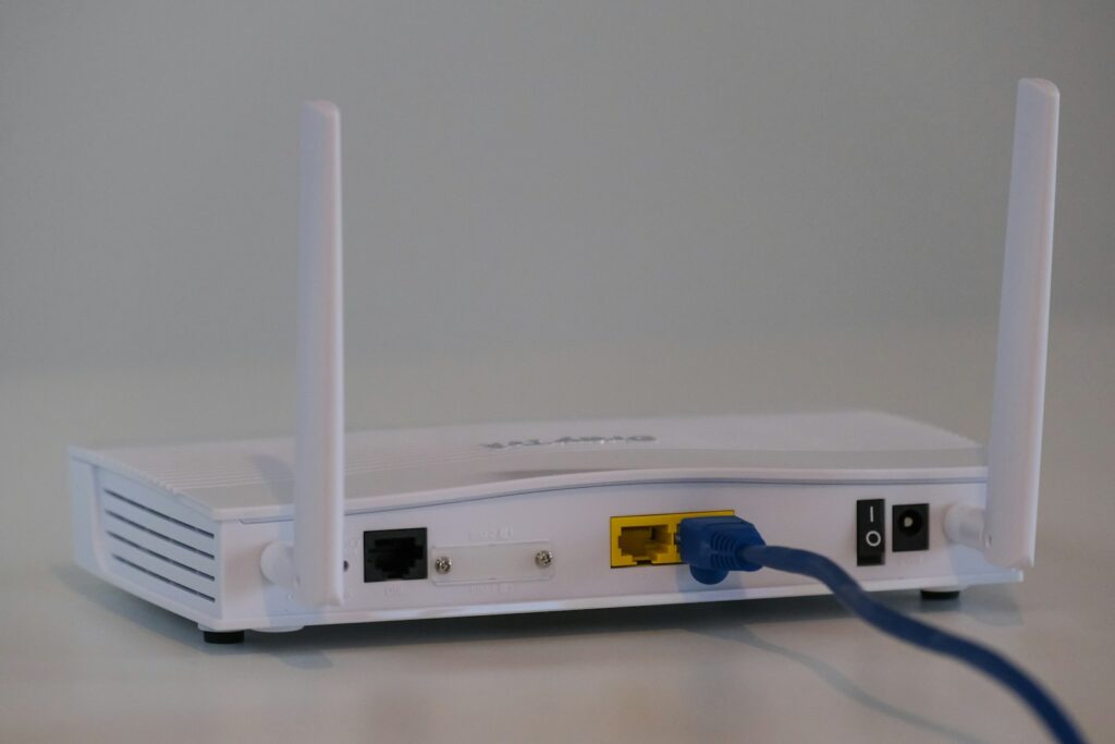 White router with an Ethernet cable connected at the rear ports