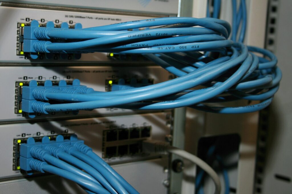 Network switches in a rack with blue Ethernet cables connected