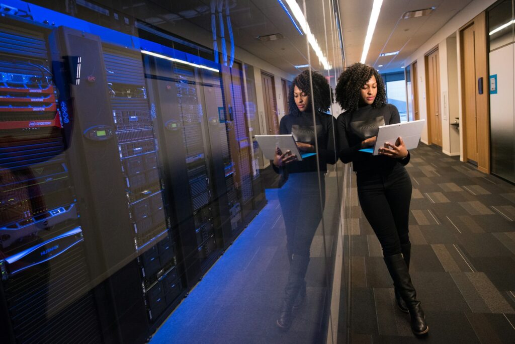 IT professionals with laptops walking through a server room